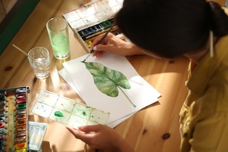 a person sitting at a table painting