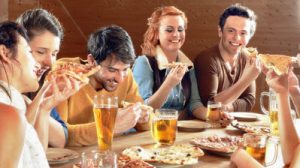 a group of people sitting at a table eating food
