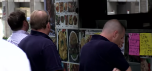 Locals ordering from a food cart in downtown NYC