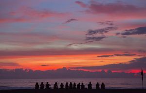 A group of people enjoying the sunset on the beach
