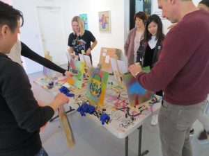 people painting at individual canvases