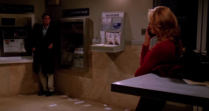 a person standing in front of an atm staring at a woman
