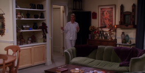 a woman standing in the living room of an apartment with furniture