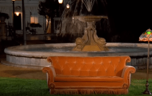 a large orange sofa in front of a fountain