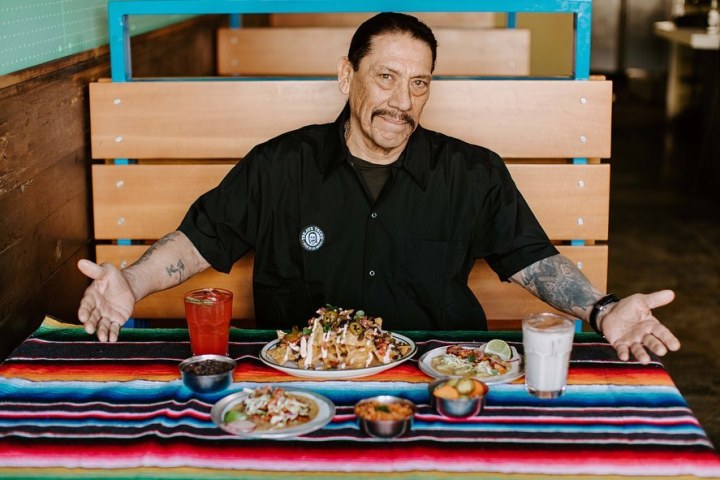 Danny Trejo sitting at a table with food