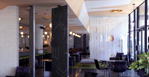 a cafe room with a high bar on the left and dining tables and chairs on the right