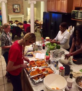 a group of women preparing food in a kitchen