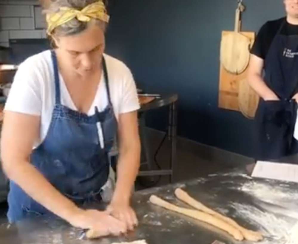 a woman rolling out dough into thin pieces