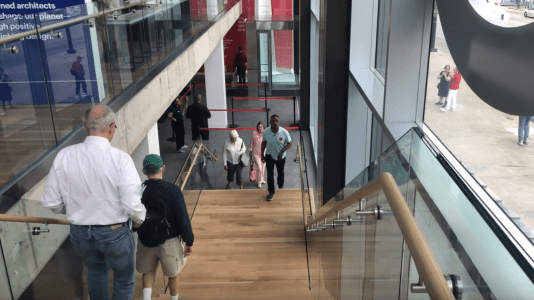the top view of a set of stairs with people walking in each direction