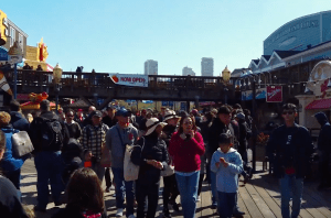 a group of people standing in front of a crowd and walking bridge