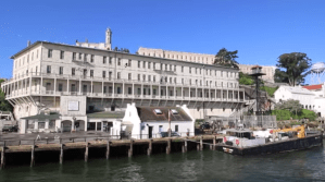 A large white building along side a boat dock