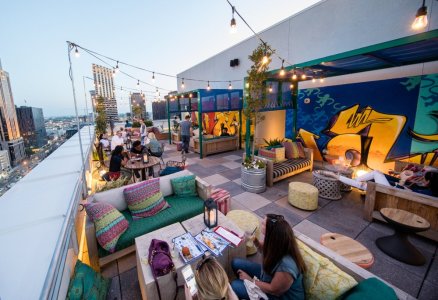 an outdoor rooftop bar with colorful couches and tables 