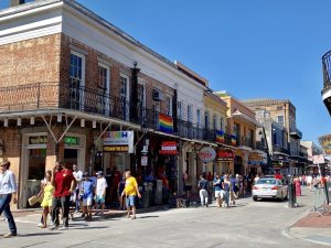 Bourbon street lined with restaurants and shops and a large group of people walking