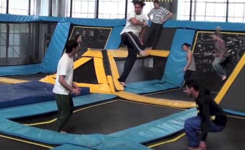 a group of people jumping on indoor trampolines