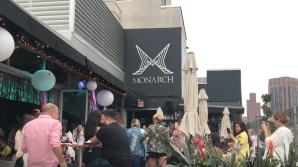 a group of people standing in front of a club on a busy street