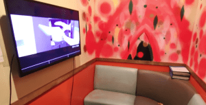 a colorful room with a screen and a lounge couch