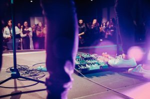 a person standing on a stage with a crowd watching