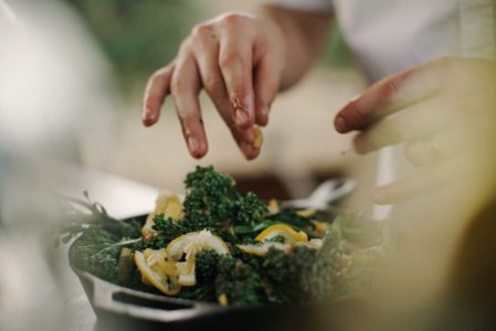 a close up of a person cutting a piece of broccoli