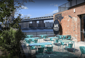 The outside view of a waterside porch at Time Out Market in NYC