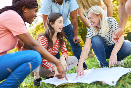 Friends with a map navigating a scavenger hunt outside