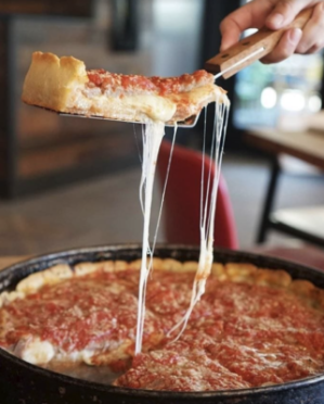 a close up of a person serving a piece of pizza
