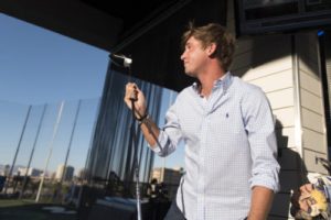 a man holding a golf club getting ready for his turn to playat Top Golf Las Vegas