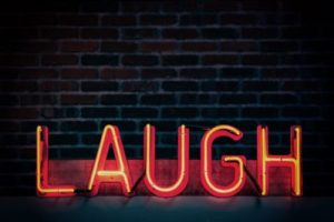 red and orange neon light sign "laugh" all uppercase