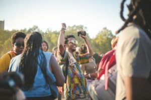 a guy dancing in the middle of a group of people at an outdoor concert