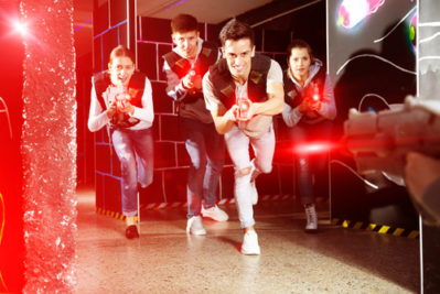 a group of teenagers/young adults playing laser tag facing the camera
