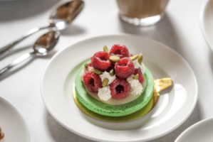 a close up of a plate with a gourmet green dessert with berrieson a table