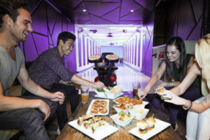 a group of people grabbing food on a table