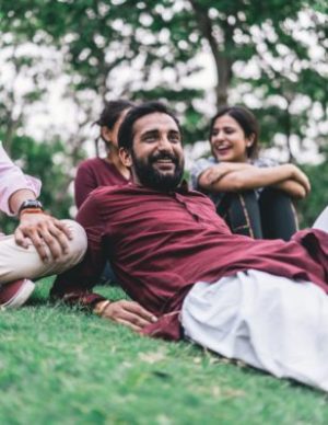 a man laying in a park with some friends spending time outside