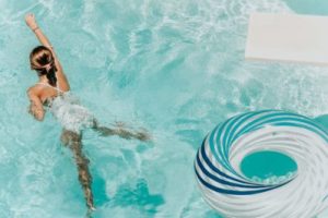 A woman swimming with a float in a pool
