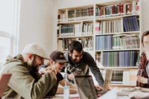 a group of guys working on something together on a computer