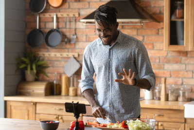 a person preparing food in a kitchen looking at their digital cooking class on their phone