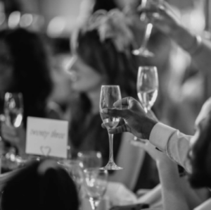 a group of people cheersing in at an event in a black and white photo