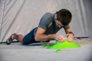 a man bouldering at an indoor rock climbing wall