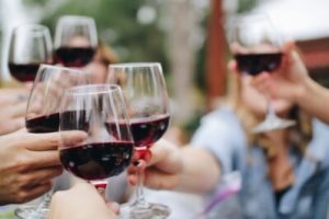 a group cheersing with red wine