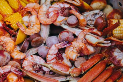 sunira-moses-QZ5BHtltNHo-unsplash a shrimp boil with shrimp, sausage, corn and crab legs