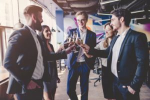 A corporate event with people in office attire toasting with champagne