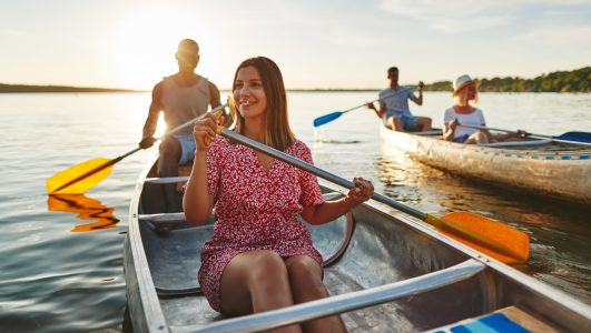 Young woman canoeing with friends on a late summer afternoon