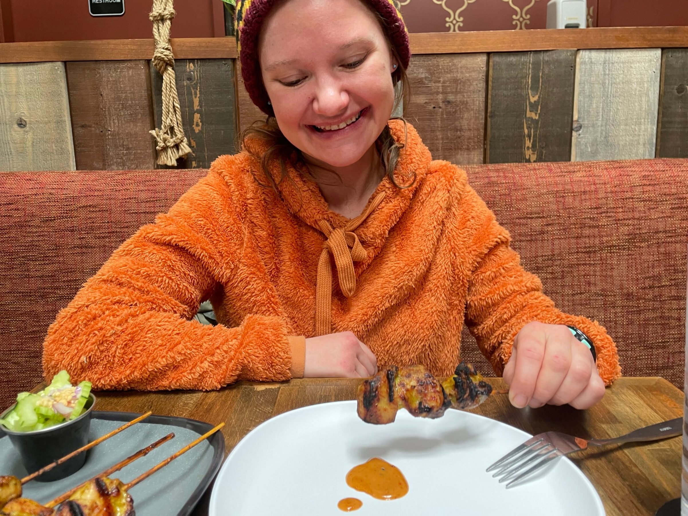 a woman sitting at a table with a plate of food