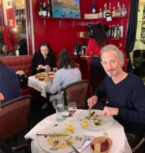 a group of people sitting at a table eating a meal at a restaurant