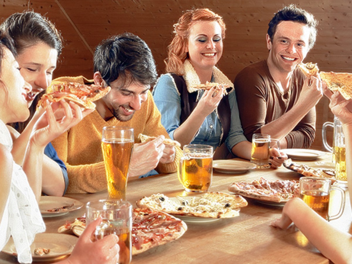 a group of people sitting at a table eating food