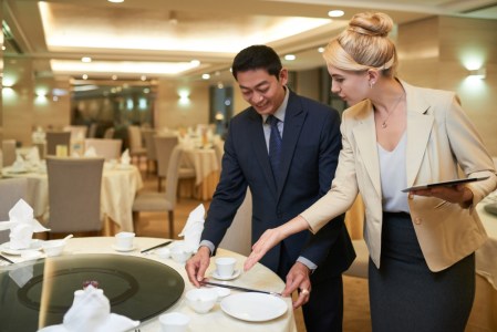 Wedding planner and banquet manager discussing table setting