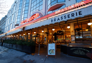 a brasserie from the exterior with a red neon sign