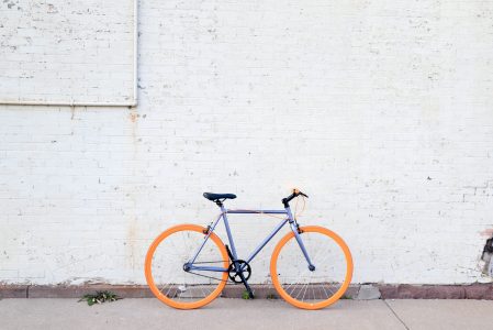 a bicycle with orange tires parked on the side of a building