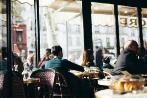 people sitting at a table at a cafe in paris