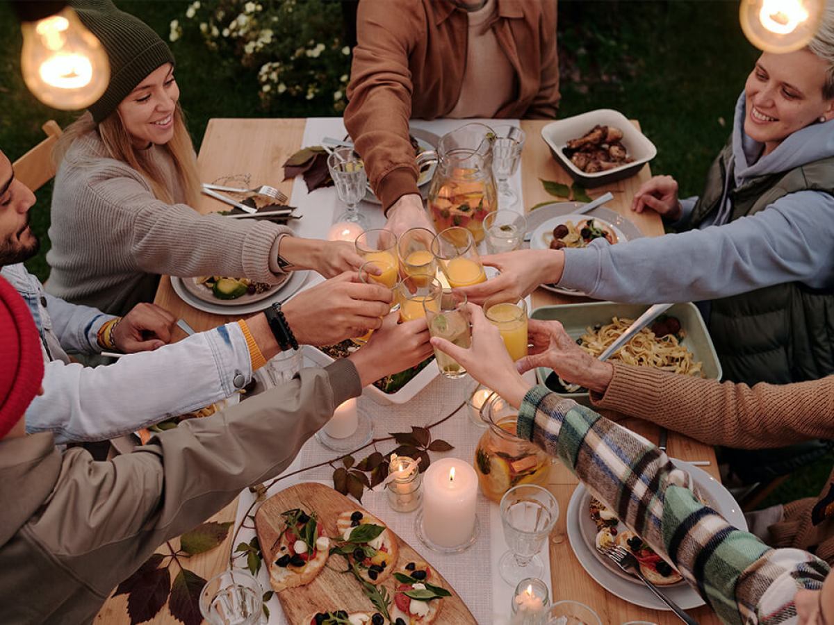 a group of people sitting on a cutting board with a cake