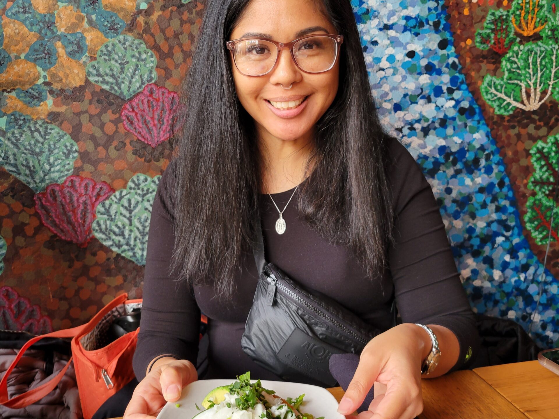 a woman sitting at a table with a plate of food
